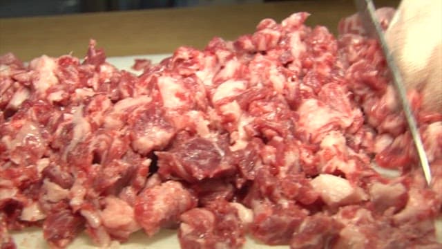 Butcher Chopping Meat in a Shop