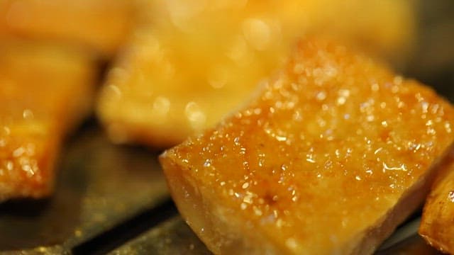Grilling pork rinds on a metal grill