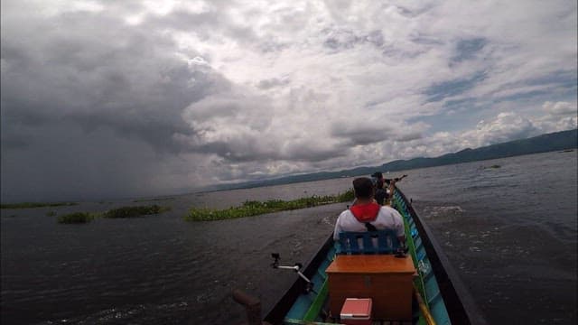 Boat ride on Inle Lake under a cloudy sky
