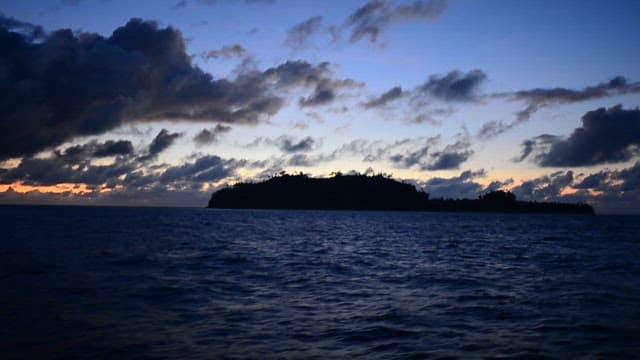 Distant island under a cloudy sunset sky