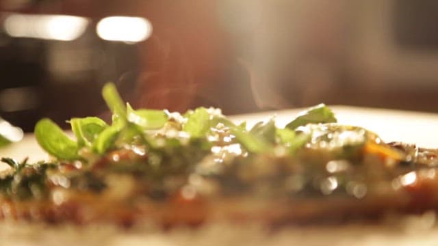 Sprinkling Cheese on a Freshly Baked Pizza