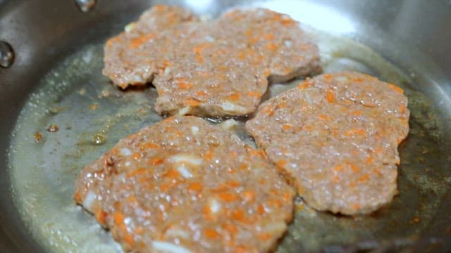 Cooking a patty in a frying pan.