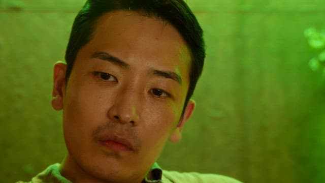 Man looking around in green light indoors