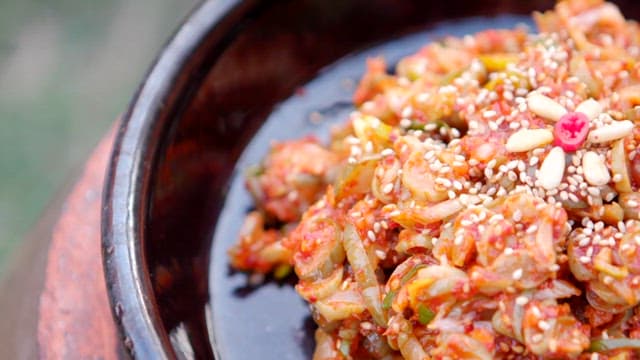 Sour pickled cucumber topped with pine nuts and sesame seeds