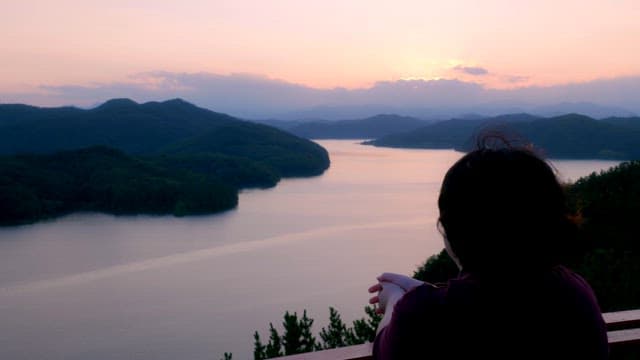 Person enjoying a serene lake view at sunset