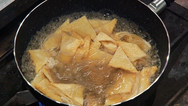 Fish cakes boiling in a pot on a stove