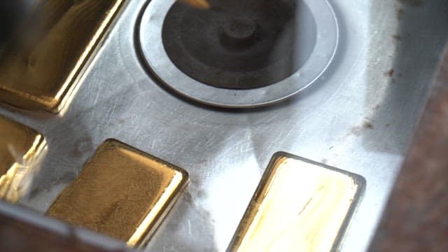 Gleaming gold bar on the metal surface