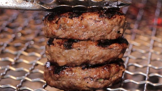Juicy grilled short rib patties being grilled on a grill