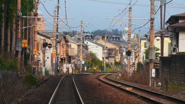 People pulling rickshaws on tracks between quiet alleys