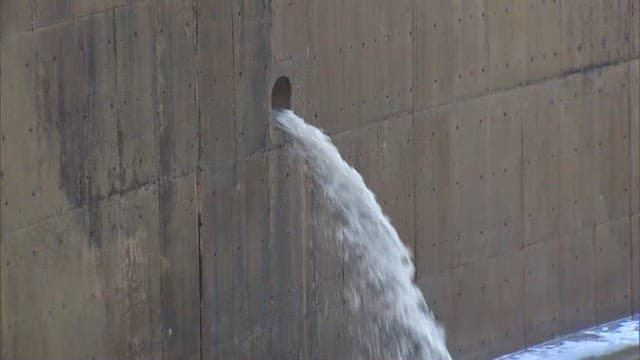 Water exiting from drain in concrete wall