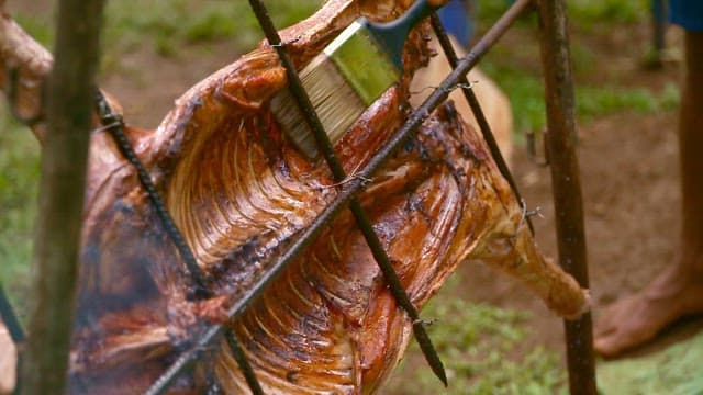 Rubbing oil on meat for whole pig barbecue