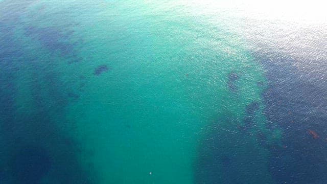 Emerald sea with terrain reflected in the water