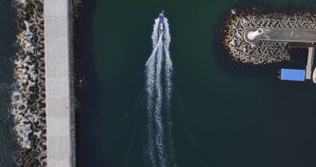Boat sailing between breakwaters