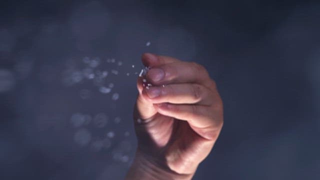 Hand scattering white crystals