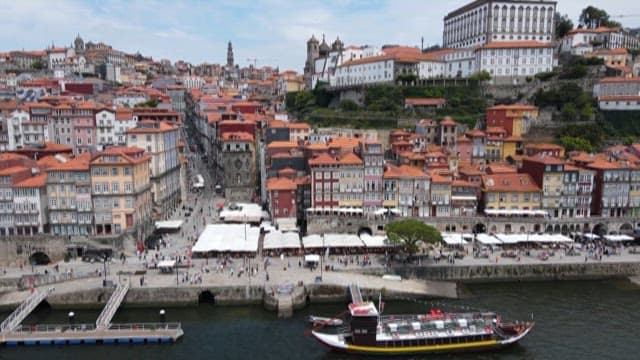 Panoramic View of a Riverside City with Red-Tiled Rooftops Boast
