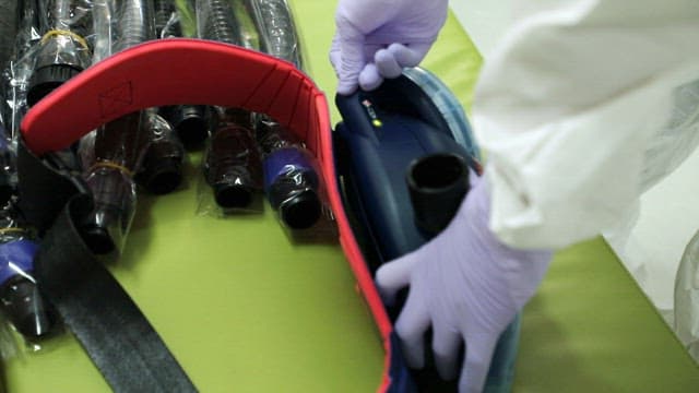 Person in protective gear handling medical equipment