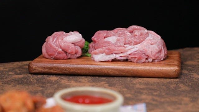 Fresh pork slices on a wooden board and fried pork