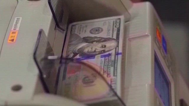 American Dollars Being Counted on a Counting Machine of Bank