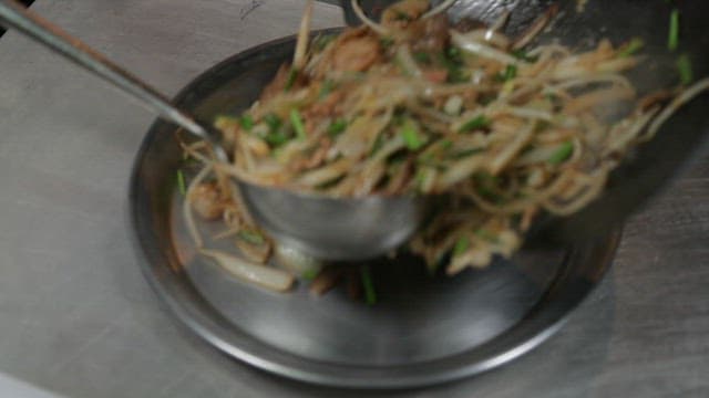 Stir-fried vegetables and meat being served on a plate