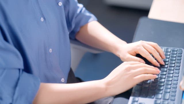 Person typing on a keyboard in an office