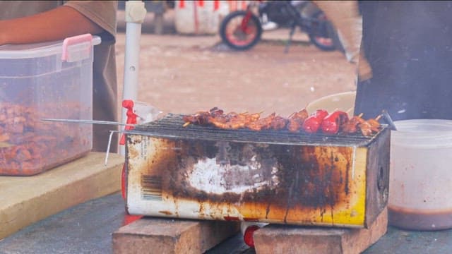 Street vendor grilling skewers