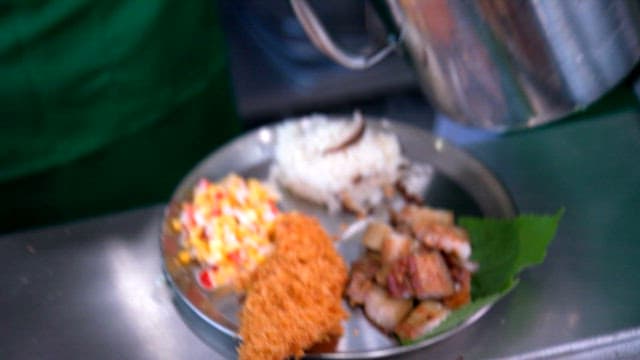 White sauce served on a metal plate with pork, salad and fried fish