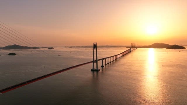 Bridge over calm waters at sunset