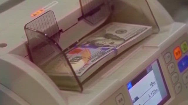 American Dollars Being Counted on a Counting Machine of Bank