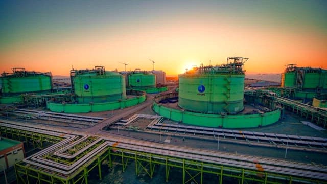 Aerial view of industrial site with storage tanks at sunset
