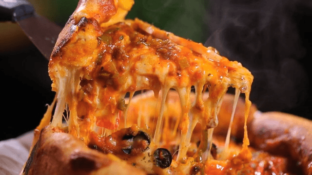 Cheese Chicago pizza slice being lifted with melted cheese