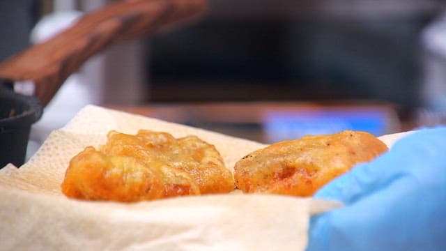 Freshly fried, golden-brown eel is taken out and placed on a kitchen towel