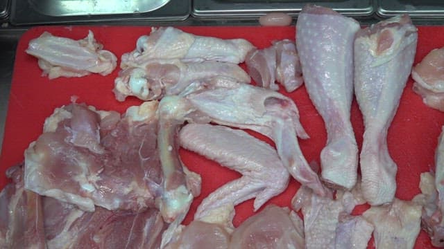 Chicken trimmed on a red cutting board