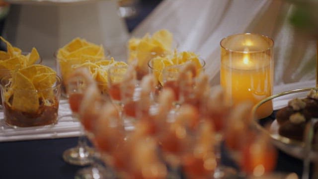 Table of various appetizers and snacks decorated with lit candles
