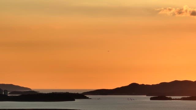 Sunset over a calm sea with distant islands