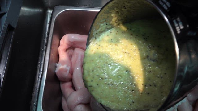 Seasoning tripe in a metal container in the kitchen