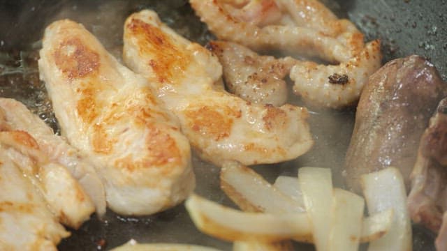 Chicken grilled on a hot iron plate with onions