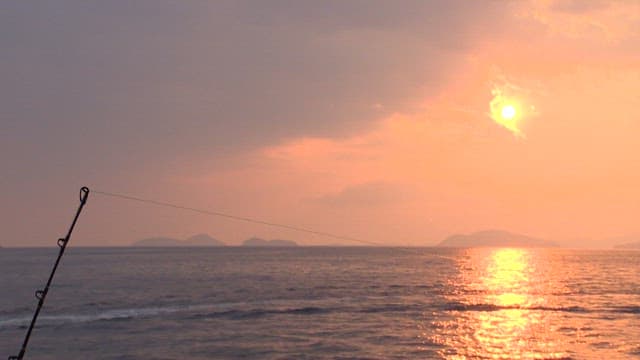 Sunset sea with fishing rods visible