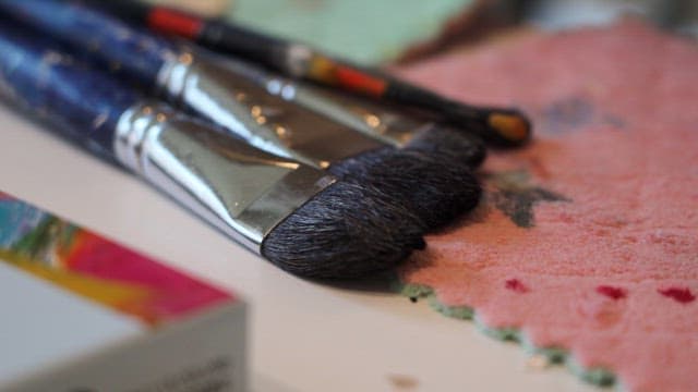 Paintbrushes on a textured pink cloth