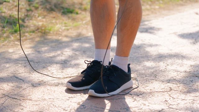 Person jumping rope on a sunny path