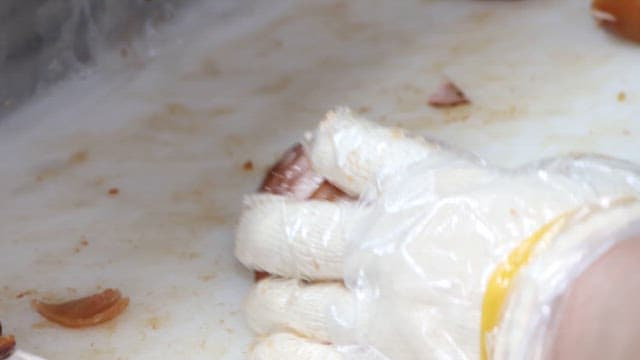 Slicing Glazed Roast Pig's Feet in Kitchen