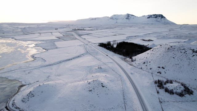 Snowy landscape with mountains and a road