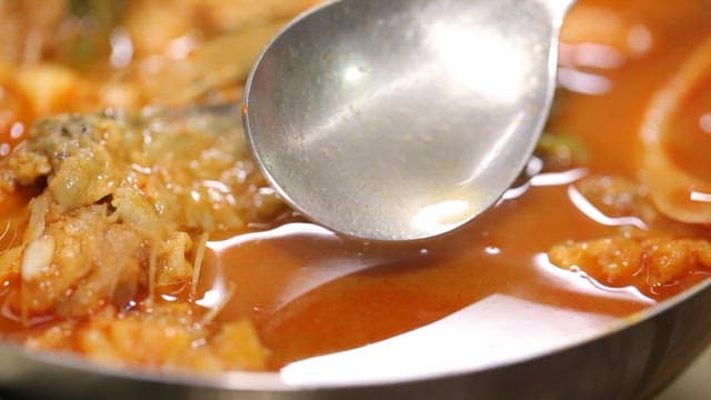 Spicy shaggy sea raven stew with a spoon