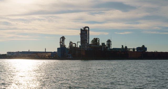 Industrial plant near the sea under the evening sunset sky