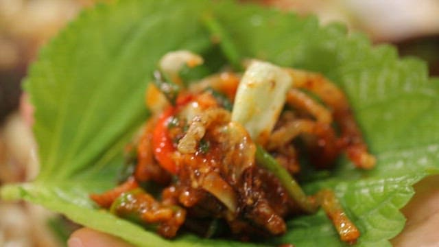 Stir-fried white sundae in perilla leaf served with pickled radish