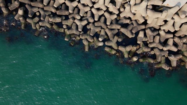 Aerial view of a coastal road with tetrapod wave breakers
