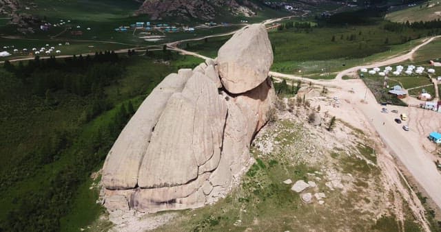 Large rock formation in a green landscape