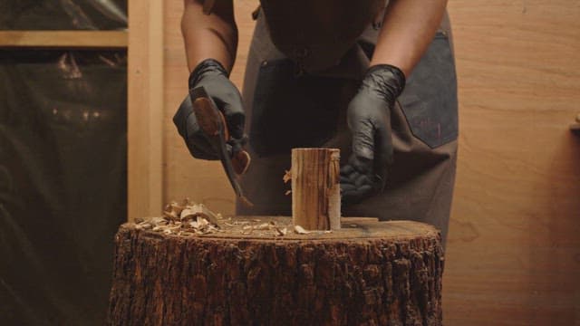Person carving wood indoors