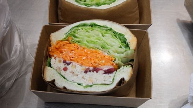 Fresh sandwiches plated in boxes and bowls