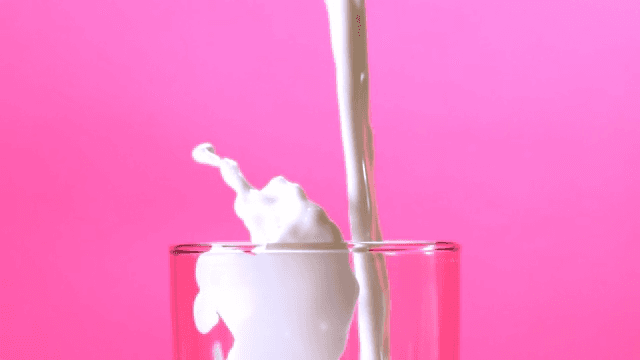 Milk pouring into a glass with a splash