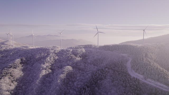Wind Generators on Misty and Snowy Mountain in the Morning